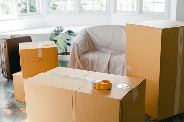  boxes, a covered couch and a suitcase
